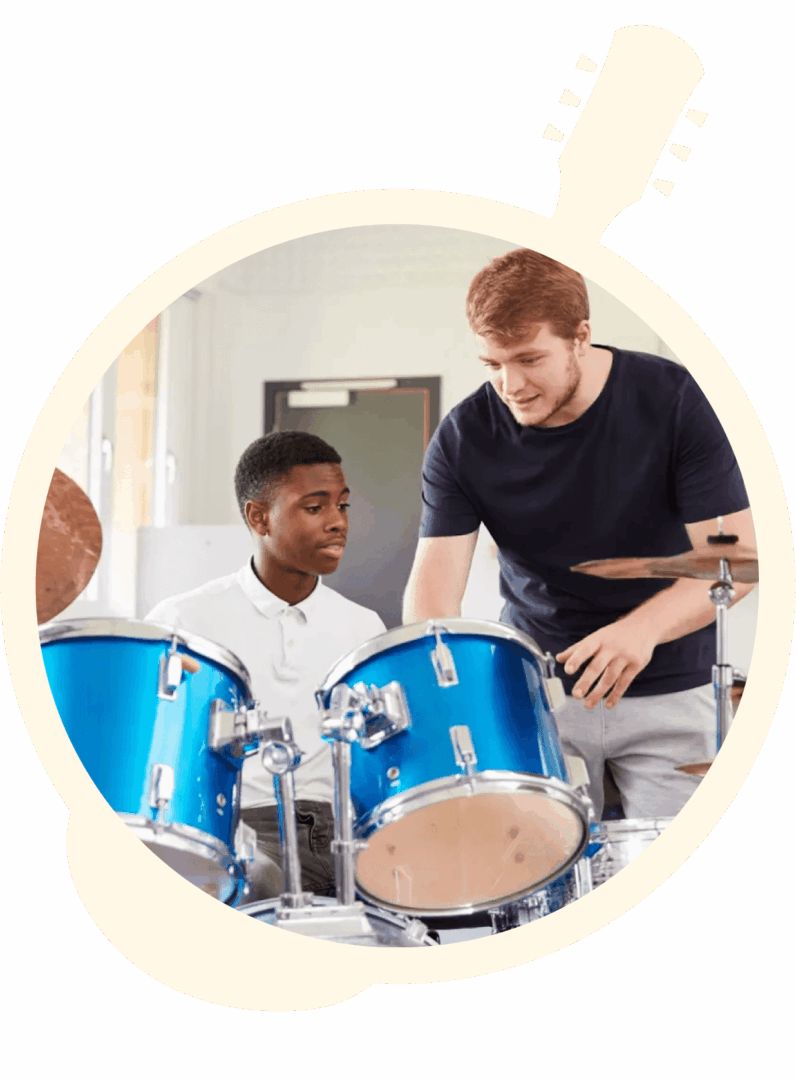 Two young men are playing drums in a room.
