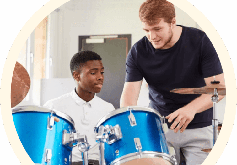 Two young men are playing drums in a room.